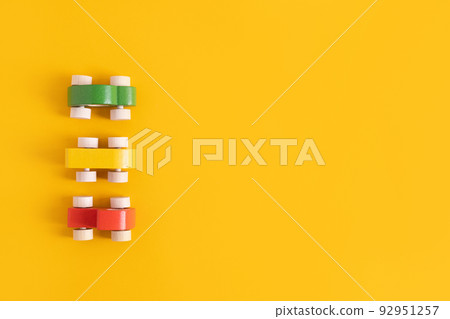 Wooden toy car in cartoon style on yellow background. Colorful and Transportation background, eco kid toys Montessori .  92951257