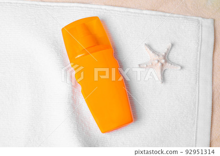 Sunscreen spf oil or cream on the sand on light background. Closeup sea sand beach. Nature orange background.  92951314