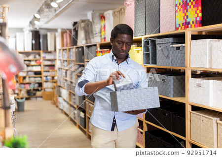 African american man chooses laundry box in store African american man chooses laundry box in store 92951714