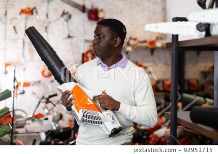 Man choosing leaf blower in gardening tools store Man choosing leaf blower in gardening tools store 92951715