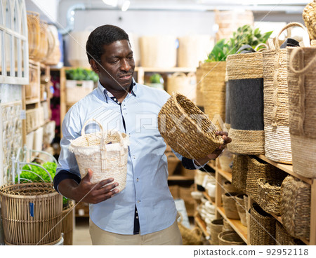 Man choosing wicker basket at hardware store 92952118