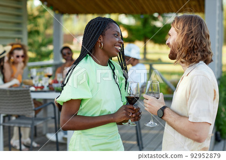Couple of Friends Chatting Outdoors at Party Couple of Friends Chatting Outdoors at Party 92952879