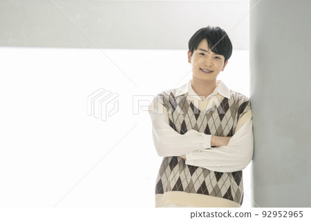 A man in his twenties smiling looking at the camera 92952965