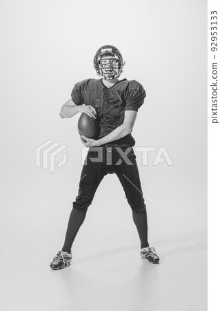 Portrait of young man, american football player posing. Black and white photography. Motivated sportsman. Winning game Portrait of young man, american football player posing. Black and white photography. Motivated sportsman. Winning game 92953133