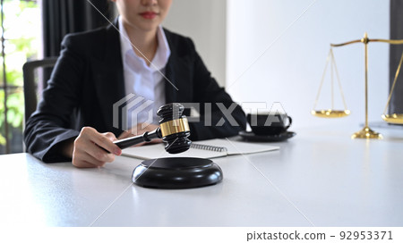 Close up view female judge or lawyer holding a gavel in hand. Lawyer, justice and law and attorney concept 92953371