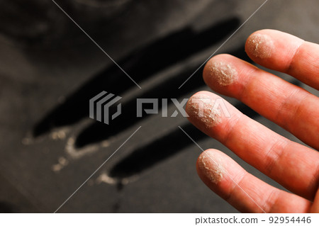 caucasian hand with dust on finger tips after touching black dusty surface 92954446