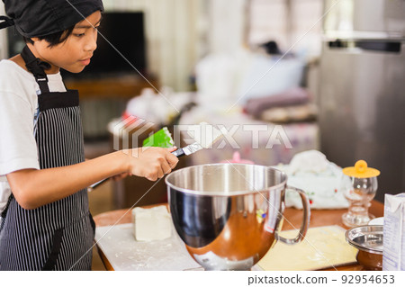 Young boy preparing ingredient for baking cake in kitchen. 92954653