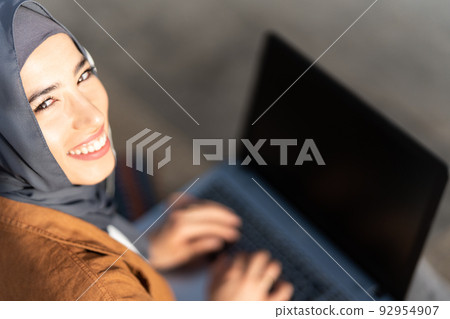 Top view of a smiling muslim woman working with laptop 92954907