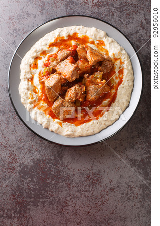 Sultan delight Hunkar begendi is an Ottaman dish that consists of a lamb stew served over an eggplant bechamel sauce closeup in the plate. Vertical top view 92956010