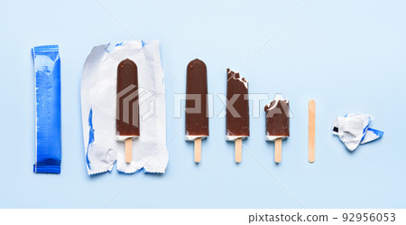 Chocolate covered ice cream on wooden stick at different states of consumption life cycle  92956053