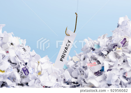 Word Privacy hooked on fishing hook pulled from pile of shredded documents on blue background Word Privacy hooked on fishing hook pulled from pile of shredded documents on blue background 92956082