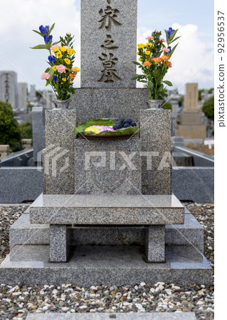 Grave with beautiful flowers, sweets and grapes 92956537