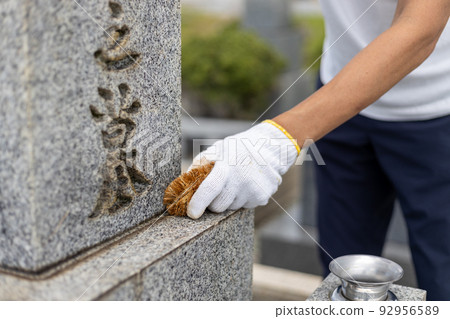 一個男人參觀墳墓和清理墳墓 92956589