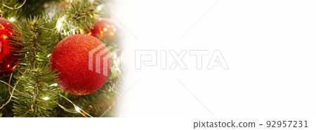 New Year's banner with a red Christmas tree toy and space for text. Copy space. Layout for design. Close-up. White background. New Year's banner with a red Christmas tree toy and space for text. Copy space. Layout for design. Close-up. White background. 92957231