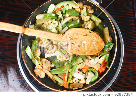 cooking fresh vegetables in a pan, top view  92957394