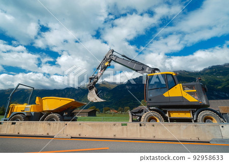 Yellow medium wheeled excavator with mini dumper 92958633