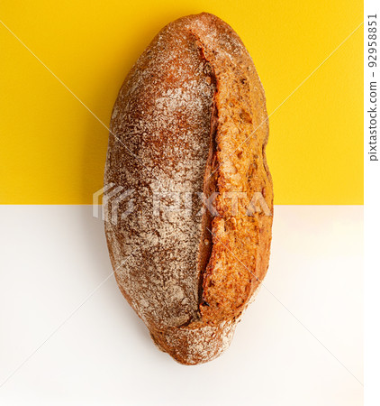Artisan bread on white and yellow background. One loaves on wheat bread on white background. Artisan bread on white and yellow background. One loaves on wheat bread on white background. 92958851