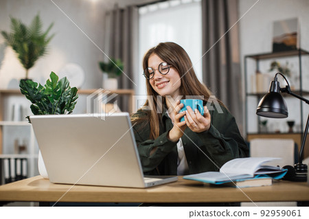 Happy laughing woman talking and smiling during video chat on modern laptop. Happy laughing woman talking and smiling during video chat on modern laptop. 92959061