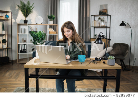Portrait of beautiful female IT specialist typing on keyboard of modern laptop. Portrait of beautiful female IT specialist typing on keyboard of modern laptop. 92959077