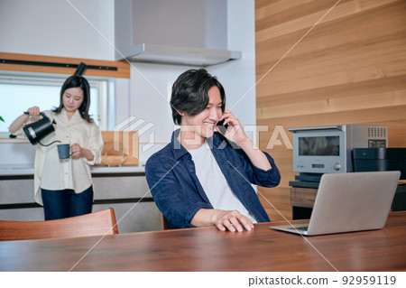 一個在遠程辦公時打電話的男人和一個喝咖啡的女人 一個在遠程辦公時打電話的男人和一個喝咖啡的女人 92959119