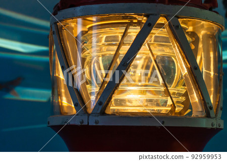 Yellow lighthouse lamp glows in metal frame Yellow lighthouse lamp glows in metal frame 92959953