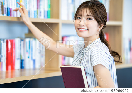 從書架上選書的年輕女子 92960022