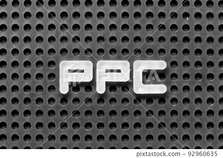 White alphabet letter in word PPC (Abbreviation of pay per click) on black pegboard background 92960635