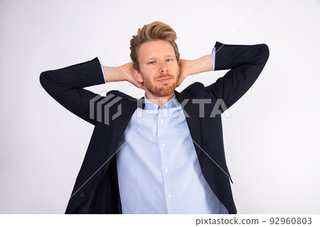 Portrait of carefree businessman standing with hands behind head 92960803