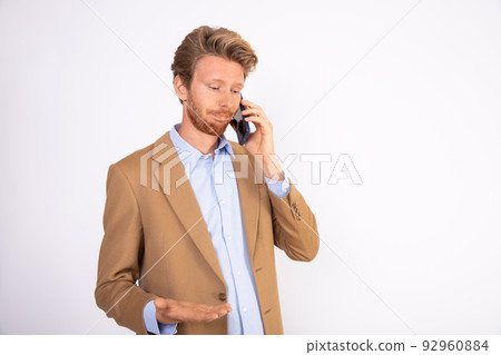 Portrait of young manager listening to client on mobile phone 92960884