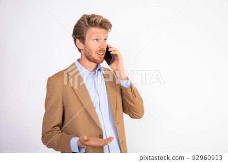 Portrait of young businessman talking to client on mobile phone Portrait of young businessman talking to client on mobile phone 92960913