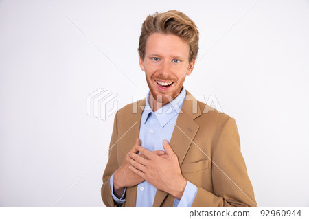 Portrait of happy businessman standing with hands on chest Portrait of happy businessman standing with hands on chest 92960944