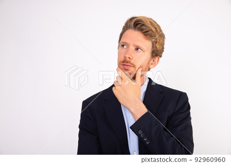 Portrait of pensive young businessman with hand on chin 92960960