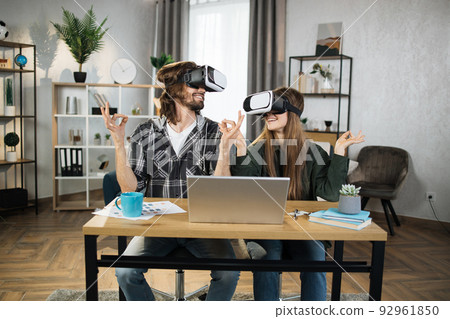 Young people playing games at home, meditating using VR glasses and laptops. Young people playing games at home, meditating using VR glasses and laptops. 92961850