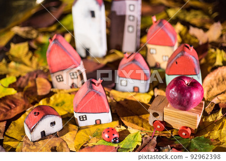 Painted toy houses on autumn leaves 92962398