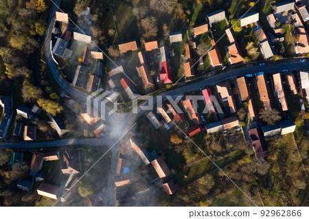 Aerial view of a misty morning above village streets and house roofs Aerial view of a misty morning above village streets and house roofs 92962866
