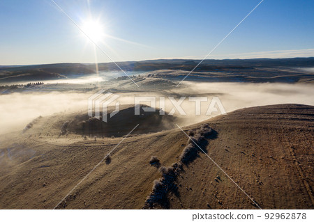 Flying over hills in mystic foggy winter morning. Aerial view Flying over hills in mystic foggy winter morning. Aerial view 92962878