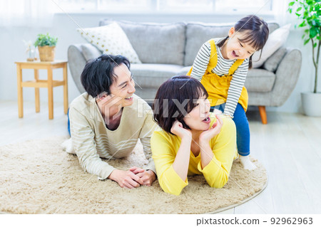 A close family lying on the floor in the living room 92962963