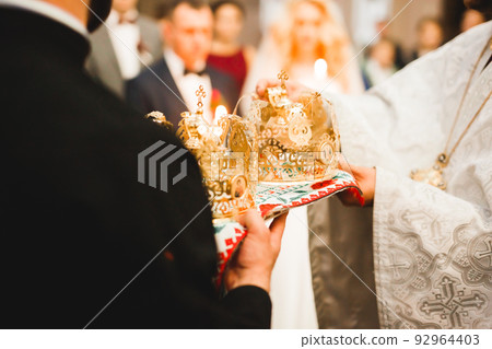 Golden crowns lying on the table in church Golden crowns lying on the table in church 92964403