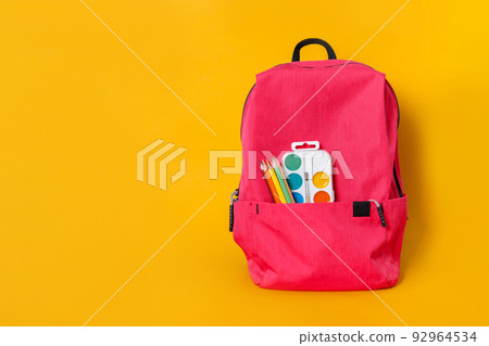 Back to school, backpack with school supplies and stationery on yellow background Back to school, backpack with school supplies and stationery on yellow background 92964534