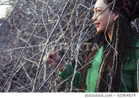 young adorable pretty girl with pigtails hairstyle smiling outside among trees close up 92964674