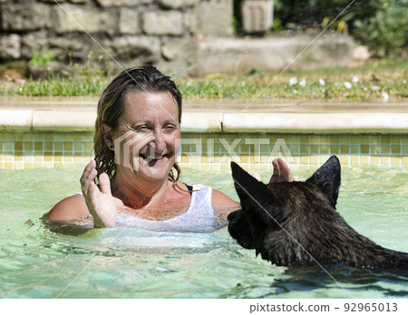 swimming Dutch Shepherd and woman 92965013