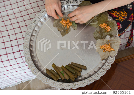 Preparing stuffed vine leaves with rice and meat, or traditional Sarma Preparing stuffed vine leaves with rice and meat, or traditional Sarma 92965161