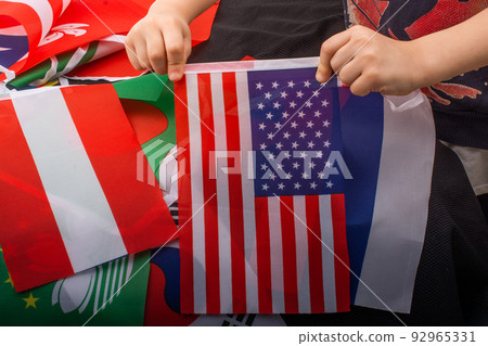 Child hand holding an American flag in hand Child hand holding an American flag in hand 92965331