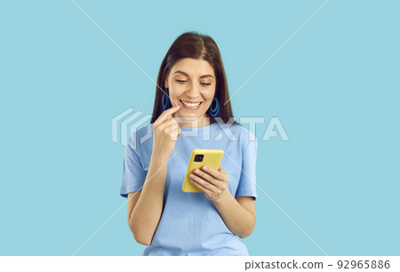 Happy young woman browse internet on cellphone Happy young woman browse internet on cellphone 92965886