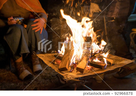 person making a campfire on a bonfire 92966878