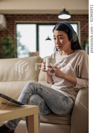 Asian woman at home watching online movie streaming subscription platform, entertainment film series internet web technology broadcasting new media digital app on laptop Asian woman at home watching online movie streaming subscription platform, entertainment film series internet web technology broadcasting new media digital app on laptop 92968951