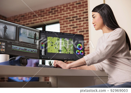 Asian videographer working on editing video and audio footage with professional software to create film content for post production. Using movie montage to edit multimedia movie. Asian videographer working on editing video and audio footage with professional software to create film content for post production. Using movie montage to edit multimedia movie. 92969003