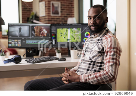 Portrait of graphic editorworking on video editing software to make film montage, creating movie footage for post production industry. Filming creator using multimedia panel to edit content. 92969049