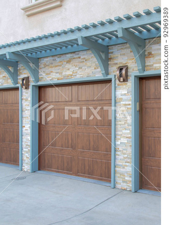 Vertical Garage exterior with wall-mounted light blue pergola and doorframe Vertical Garage exterior with wall-mounted light blue pergola and doorframe 92969389