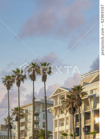 Vertical Puffy clouds at sunset Modern traditional low rise white apartment buildings at Oceansi 92969397